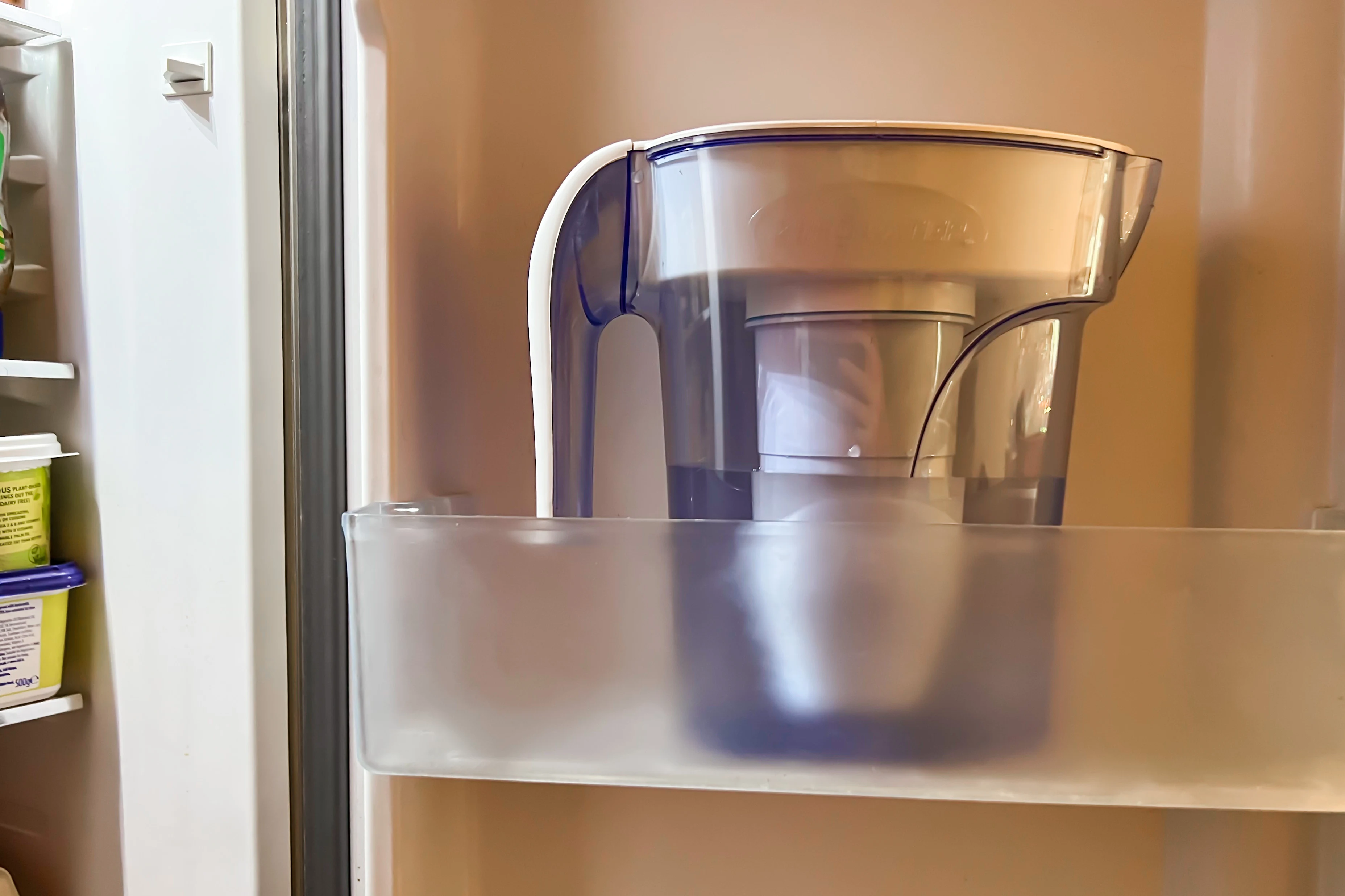 A 7 cup water jug with filter in a fridge door
