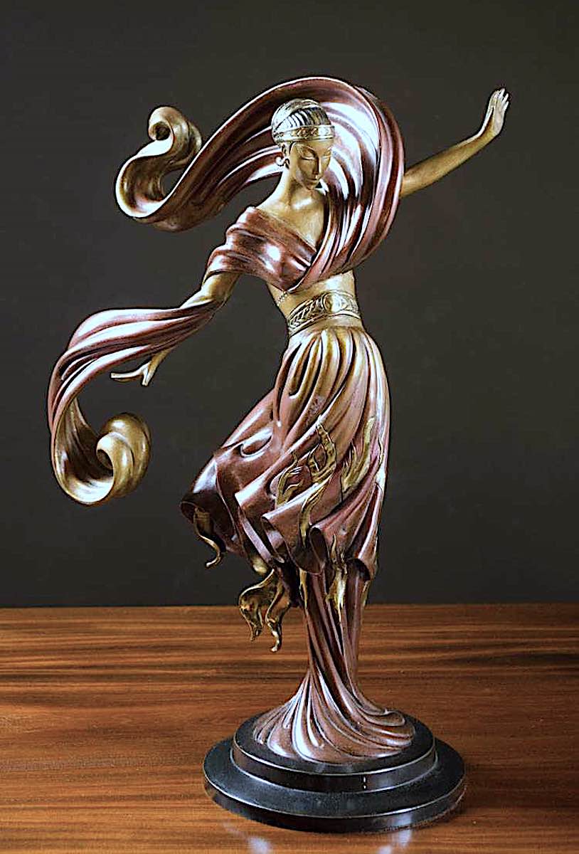 an Erté metal statuette of a woman in wind, color photograph