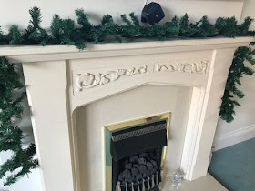 Plain green garland over a fireplace