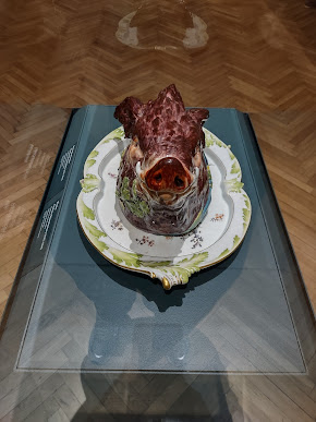 Portrait orientation photo of a porcelain tureen in the form of a pig's head, snout forward