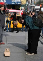 A Tweenbot on a New York City road, being admired by & perhaps assisted by strangers