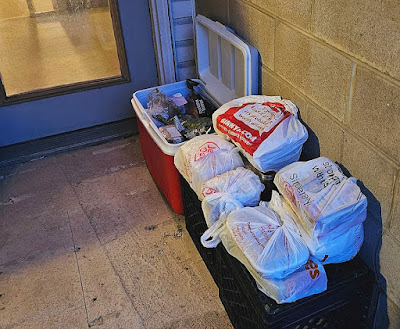 bags and icebox all loaded with food sitting outside on the rear balcony