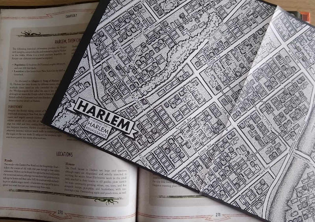 Imagen del libro abierto y, sobre él, uno de los dos mapas separables del barrio que incluye el suplemento