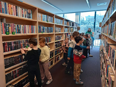 Dzieci szukające książek pomiędzy regałami.