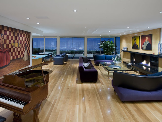 Picture of large living room with modern furniture, wooden piano and beautiful views of the city at night