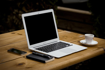 Portátil, smartphone, libreta y un café sobre una mesa