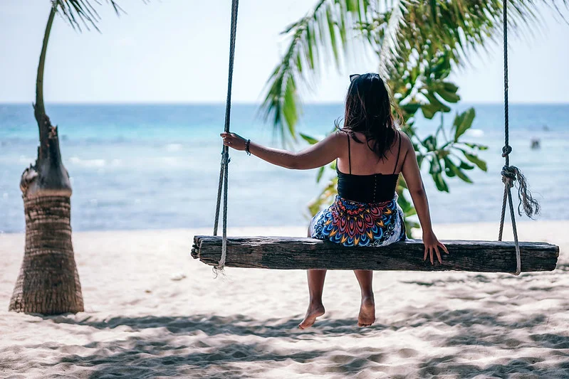 Beach swing with woman sat on - summer