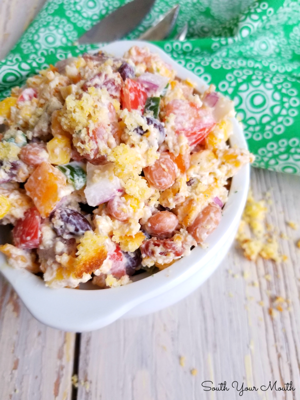 Confetti Cornbread Salad! A kaleidoscope of crisp bacon and diced fresh vegetables, creamy beans and shredded cheese tossed with sour cream dressing and crumbled cornbread in a bright, beautiful, fun salad perfect for potlucks, picnics and Sunday dinner.