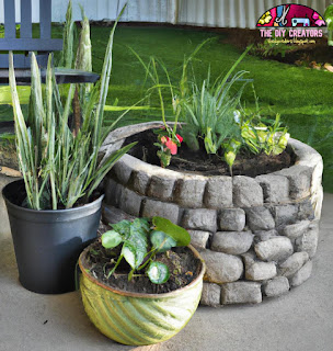 Image of a vertical garden made from a pallet leaning against a wall. Plants are growing between the slats.