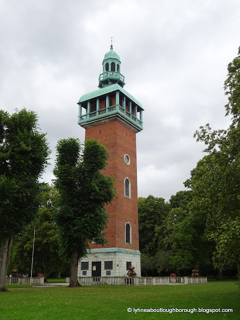 Red brick memorial tower in a park setting