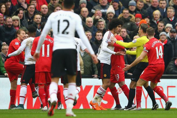 Referee Mark Clattenburg keeps Marouane Fellaini out of the way after the clash with Lucas Leiva