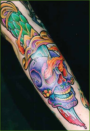 Colorful skull and dagger tattoo with flames.