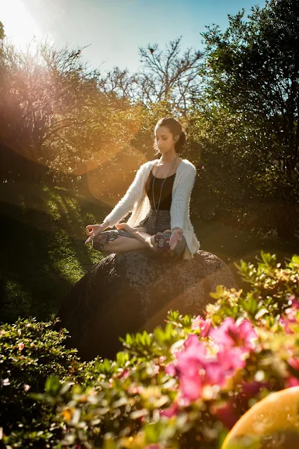 A person sitting in meditation in a tranquil natural environment, illustrating the mental clarity and peace achieved through yoga.