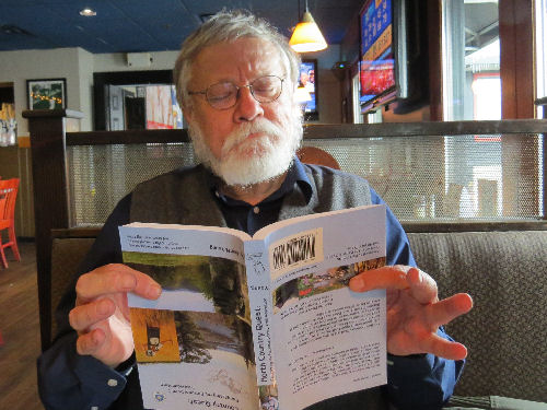 man reading a book upside down