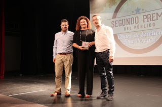 El concejal Daniel Sola y Antonio Domínguez entre el premio a Centro de Estética Ana Pereira