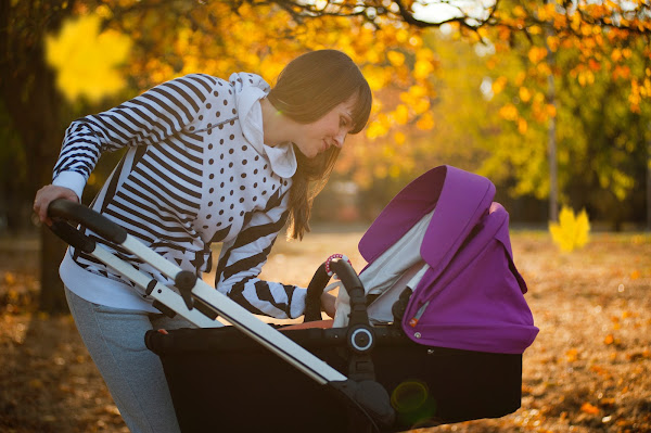 mother leaning toward baby in pram