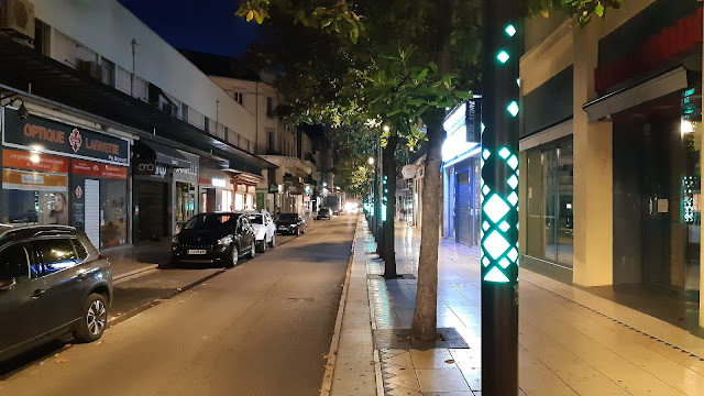 Rue Georges Clemenceau de nuit et un des candélabres émettant une couleur verte