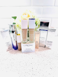 Assorted Lancôme beauty products arranged together, including foundations, concealer, serum, and peptide cream, symbolizing a complete February beauty routine.