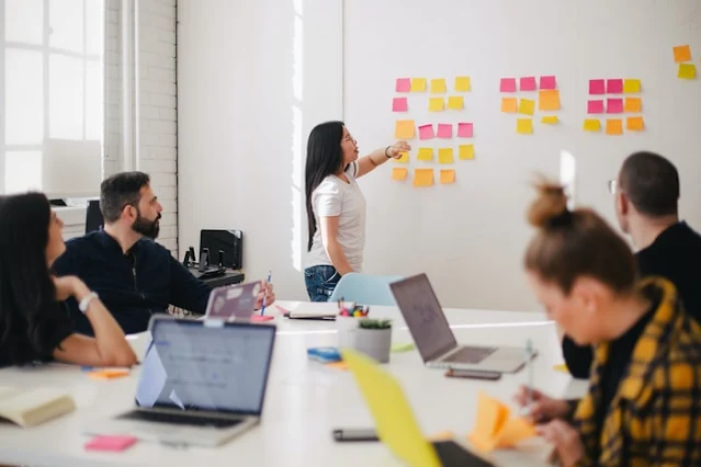 women placing syicky notes in wall