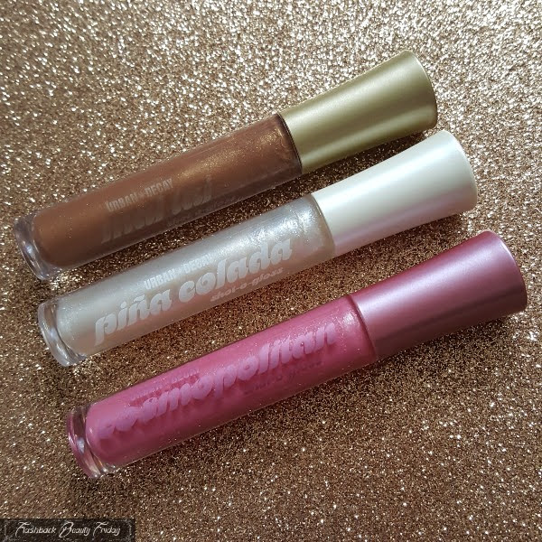 set of 3 urban decay lipglosses on glitter background