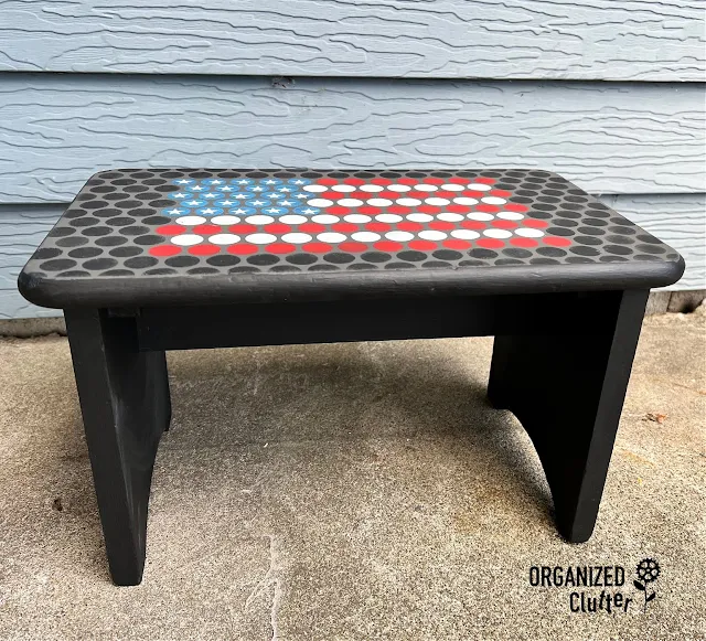 Photo of penny tile flag patterned wooden stool.