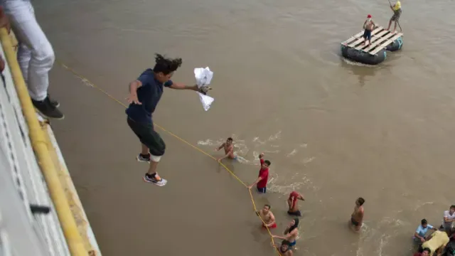 Migrants tired of waiting to cross into Mexico, jumped from a border bridge into the Suchiate River, in Tecun Uman, Guatemala