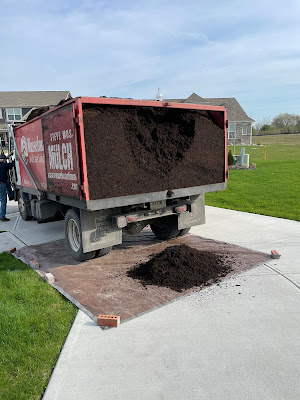 mulch being delivered in truck on driveway