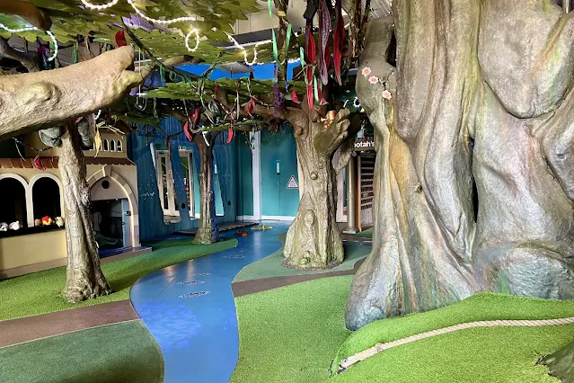 View across the ground floor story world showing a castle, pretend river and pretend trees