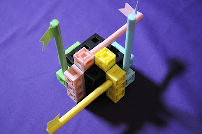 Gameplay of the boardgame Ctrl with different pastel pieces attached to a larger black cube