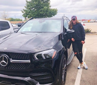 Alyssa Naeher posing for picture with a car