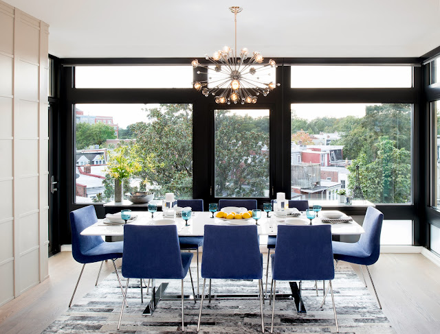 Modern dning room in a Washington DC home by Amy Elbaum with light wood floor, floor to ceiling windows, custom cobalt blue upholstered Pierre Paulin chairs and a modern chandelier