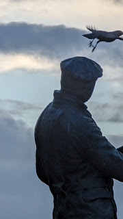 Silhouette of the statue of Charles Rolls as a bird flies of his head, Monmouth