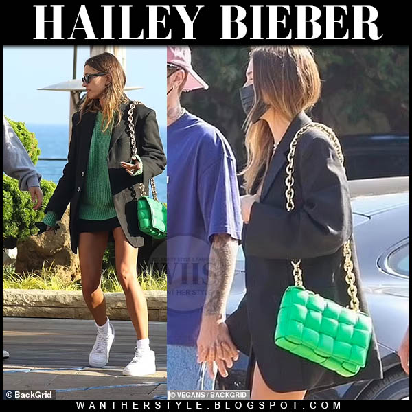 Hailey Bieber in black blazer, green sweater and green bag