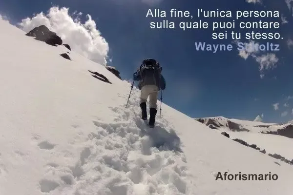 Uomo scala una montagna innevata