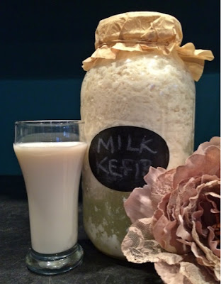 Milk Kefir - Curd separated from whey and ready to strain with a glass of ready to drink Maple Syrup Milk Kefir and random flower-y thing to make it pretty.