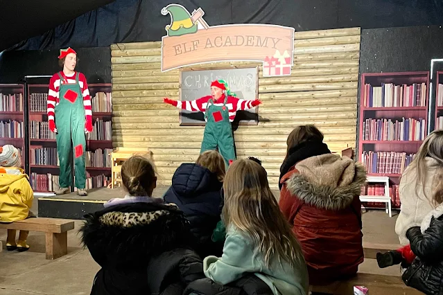 Watching two elves wearing green and red at Odds Farm Park elf academy