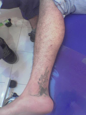 Flames ankle tattoo on guy.