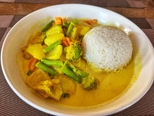 a plate of yellow vegetable curry with white rice in Laos