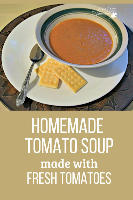 a bowl of homemade tomato soup with spoon and crackers