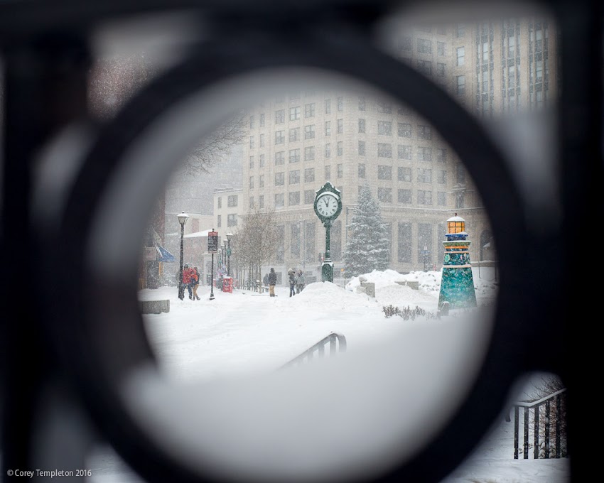 Portland, Maine USA December 2016 photo by Corey Templeton. Looking through a fence outside of One City Center towards Monument Square like a snow globe.