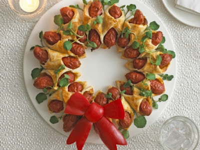 10-Fun-Christmas-Party-Food-Ideas-hotdogs-wrapped-in-pastry-placed-in-a-ring-and-baked-decorated-with-edible-red-bow.