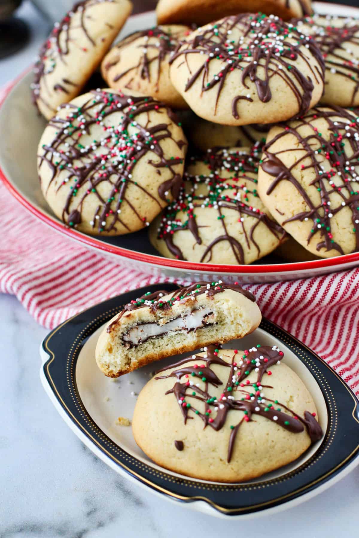 Peppermint Patty Stuffed Cookies with a bite out on a plate in front of a bowl.