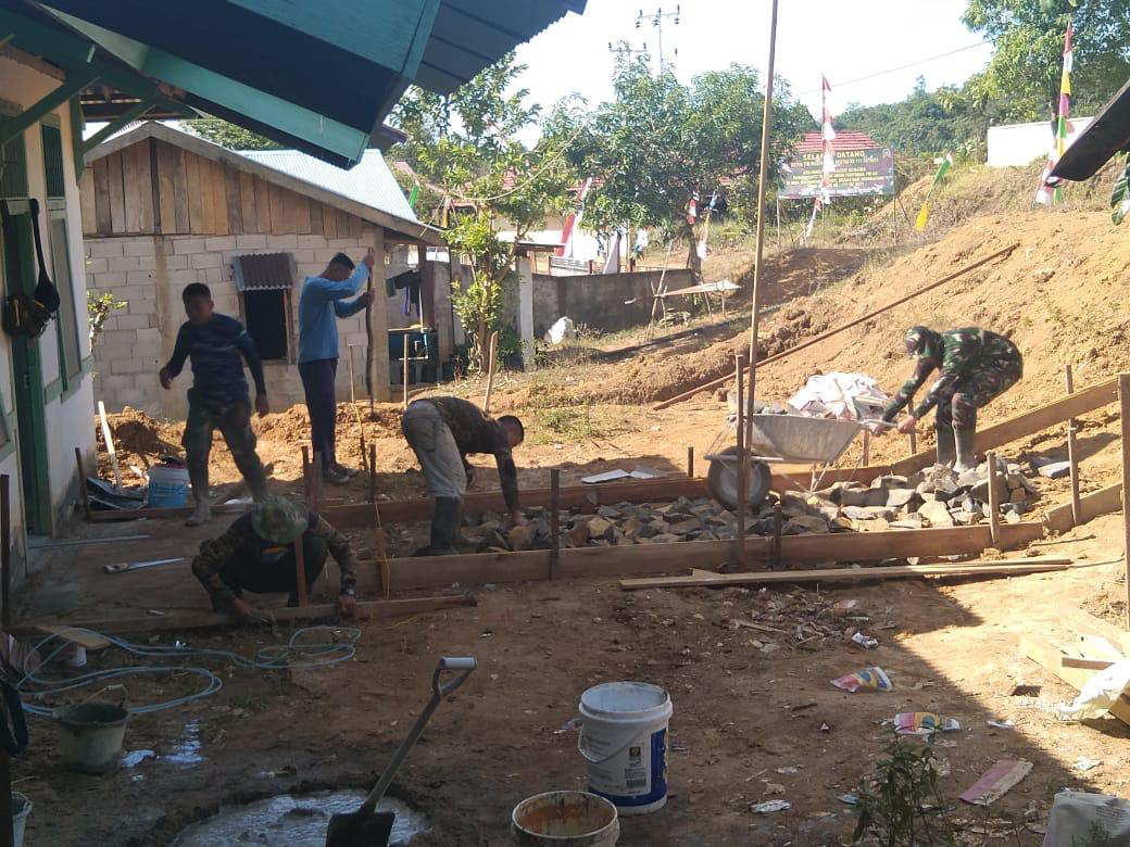 Anggota satgas TMMD bersama warga bagun jalan teras puskesmas pembantu