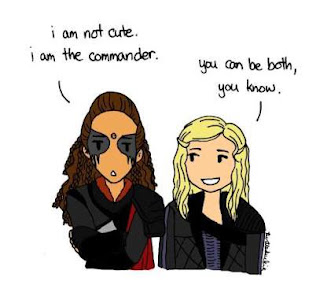 Na fanart: Um desenho de Lexa de braços cruzados dizendo que não é fofa porque é Commander ao lado de Clarke falando que ela pode ser os dois