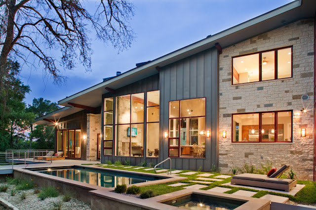 Picture of the swimming pool in the backyard by the contemporary ranch house as seen at sunset