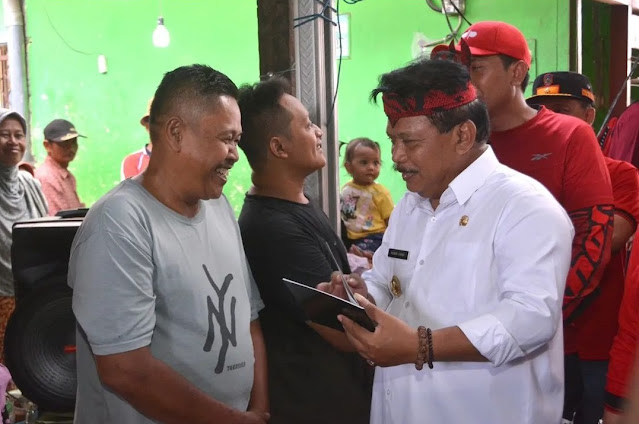 Plt Bupati Nganjuk Marhaen Djumadi secara simbolis membagikan Buku Izin Penempatan ke salah satu pedagang Pasar Rejoso, Selasa (6/9/2022)