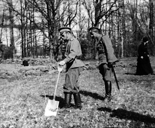 Head Nicholas II of Russia (L) holds a scoop while being under a house capture in Tsarskoye Selo 