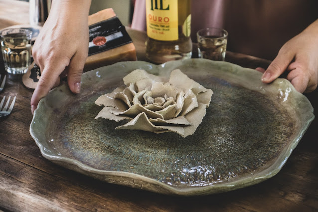 Prato e flor de cerâmica sendo colocado na mesa para refeição