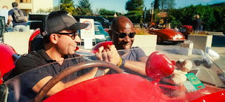 Clive Myrie with his co-host while sitting in the classic car