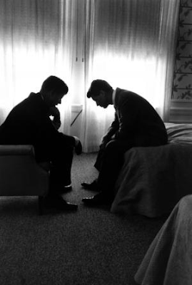 image of Presidential candidate Jack Kennedy conferring with his brother Bobby Kennedy in a hotel suite